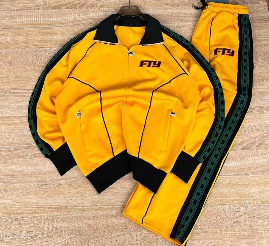 Yellow jacket and matching trousers laid flat with dark collar and cuffs.